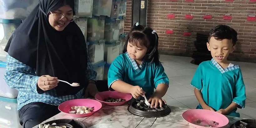 Nadif is plating food with Allea and Haidar. While working, they showed Nadif the results of their work. They chatted in their own language and laughed together.