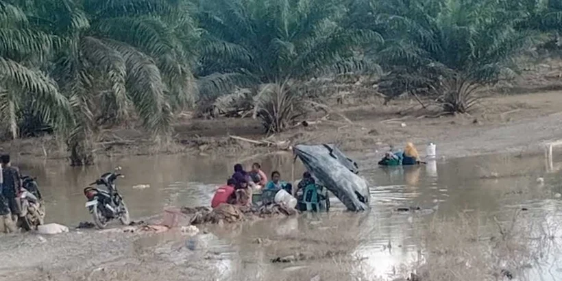 Residents of Alur Cucur village washing mud-soaked clothes in receding floodwaters. Photo by Andre