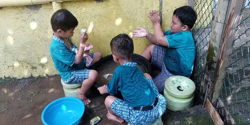 Samuel, Steven, and Aijaz like to play with water in the corner of the room.