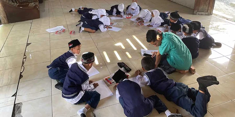 Achmad and children do a drawing activity together in the Power Of Goodness