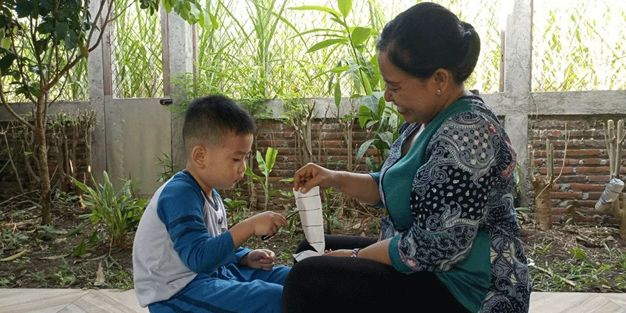 Ninok introducing a scissor activity to Royce, one of the children with special needs at Paud Joglo who still has limited words and mostly moves and walks during activities, photo taken at Paud Joglo transition room on May 17, 2024 by Nadif.